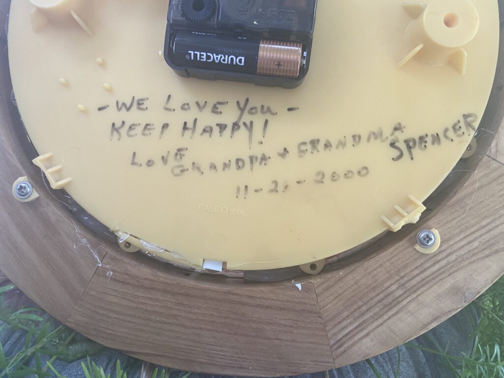 inscriition on back of cock. one of the plastic tabs holding the clock together appears to be broken. a single AA battery runs the clock
