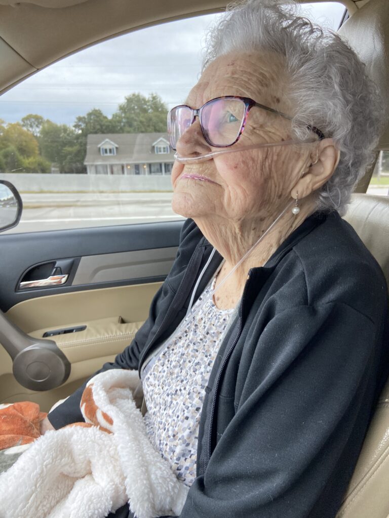 old lady in passenger seat, lap covered with blanket